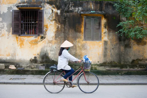 Mulher está andando de bicicleta passado — Fotografia de Stock