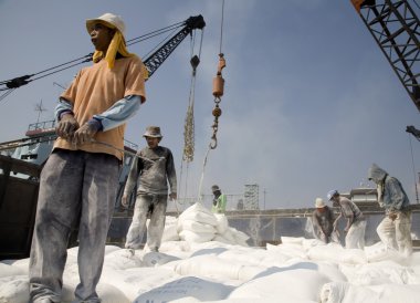 Indonesian port workers unload a ship with a cement bags cargo in a traditional way in Sunda Kelapa clipart