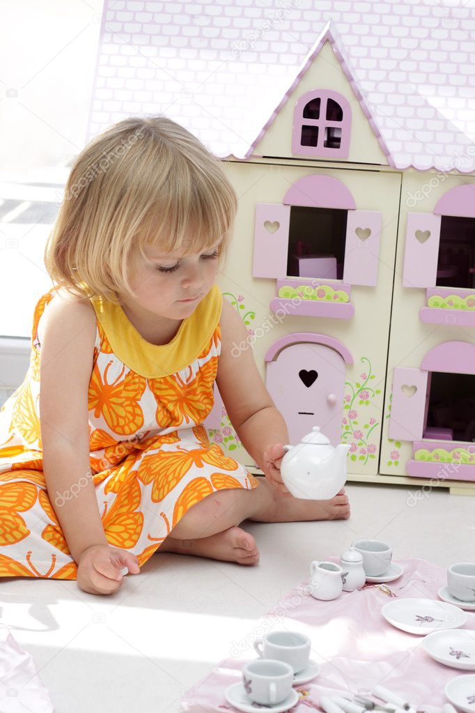 Girl playing with teapot set