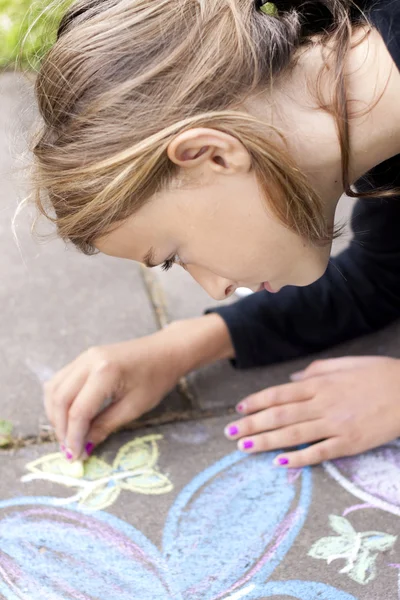 Girl drawing with chalk on pavement — Stock Photo, Image