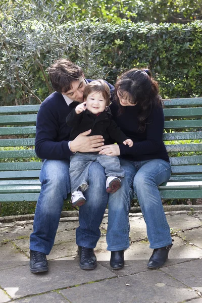 Asian mother caucasian father and child on a parkbench — Stock Photo, Image