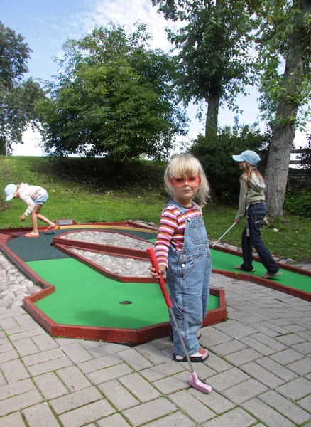 Дети играют в мини-гольф — стоковое фото