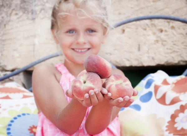 Dziewczyna trzyma się brzoskwinie — Zdjęcie stockowe