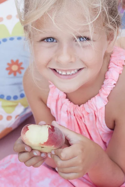 Dziecko jedzenie płaskie brzoskwinia — Zdjęcie stockowe