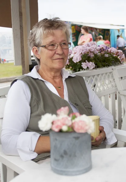 Oude vrouw in café — Stockfoto