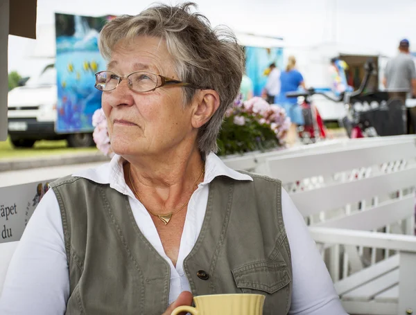 Old woman drinking coffee — Stock Photo, Image