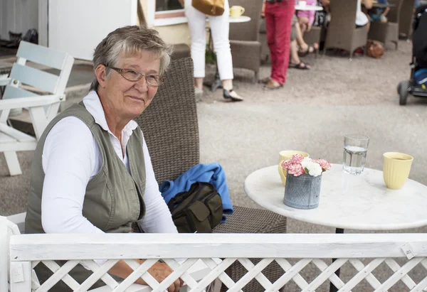 Oude lachende vrouw in café — Stockfoto