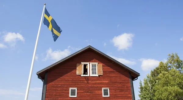 Antigua casa de madera sueca con asta de bandera — Foto de Stock