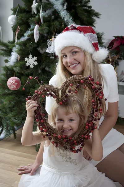 妈妈和女儿的圣诞花环 免版税图库照片