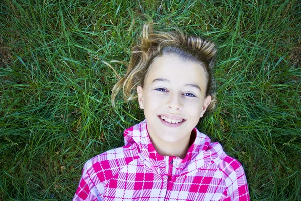 Dívka ležela na trávě při pohledu na fotoaparát — Stock fotografie