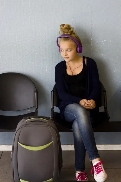 Dívka s sluchátka čekají na cestování — Stock fotografie