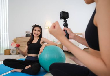 Genç bir çift Asyalı kadın köpeğiyle antrenman yapmak ve oynamak için evde uzun zaman geçirir..