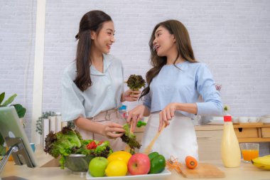 Genç Asyalı çift evde salata pişirmeyi sever..