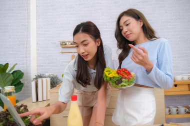 Genç Asyalı çift evde salata pişirmeyi sever..