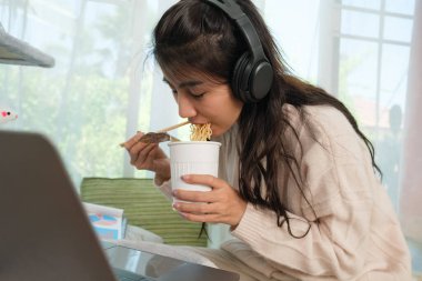Young Asian woman working from home with her cat at home.