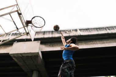 Genç Causian basketbolcusu sokak sahasında top oynuyor..