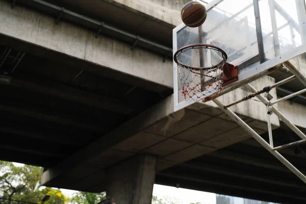 空気中のバスケットボールがフープに落ちる — ストック写真