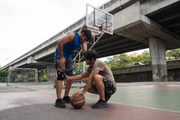 若い男バスケットボール選手の怪我からバスケットボールをプレイ — ストック写真