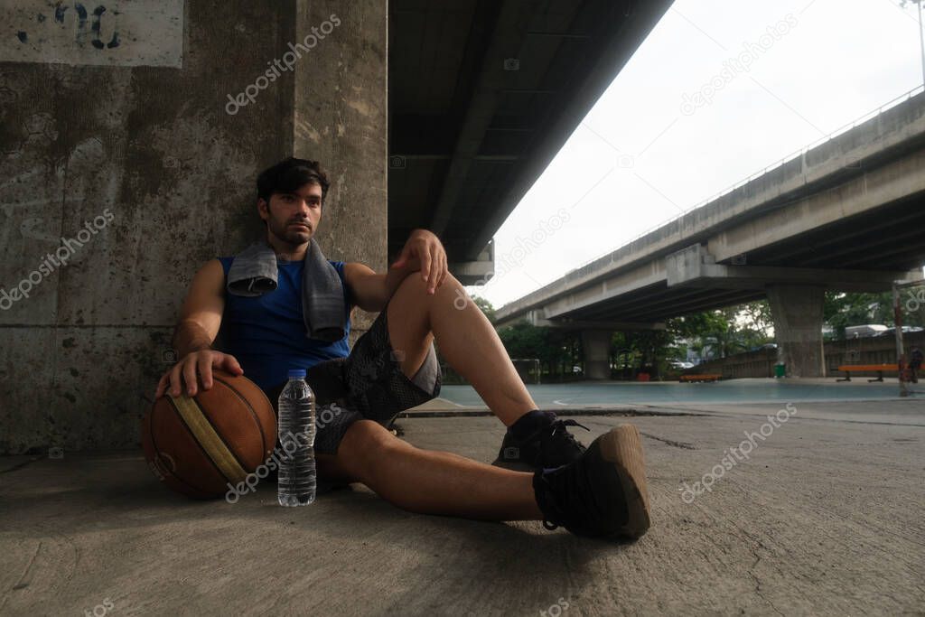 Young causian basketball player resting and ralax. 