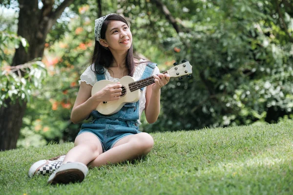 Молодая Азиатка Отдыхает Парке Играет Маленькой Гитаре Парке — стоковое фото