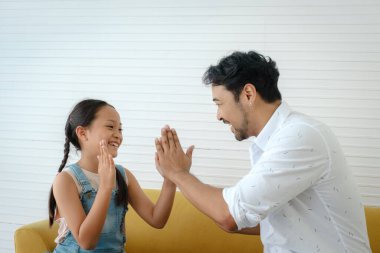 Asyalı baba ve kızı evde birlikte oynamaktan hoşlanırlar.