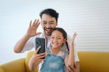 Asyalı baba kızıyla selfie çekmeyi sever..