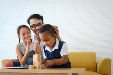 Asyalı görünümlü oğlu ve kızı birlikte oynuyorlar..