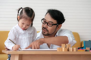 Father and daughter spending times on weekends to playing together.
