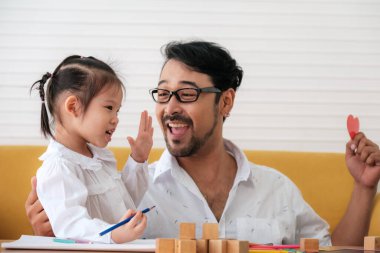 Father and daughter spending times on weekends to playing together.