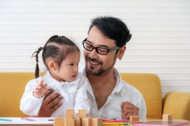 Father and daughter spending times on weekends to playing together.