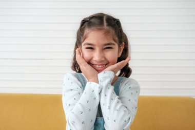 Close up of Asian girl siting on sofa with cute action.