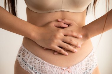 İç çamaşırlı genç kadının midesi ağrıyor..