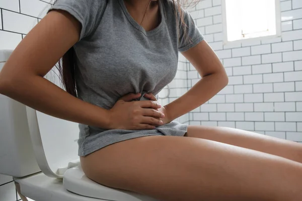 トイレや胃の痛みに座っている若い女性 — ストック写真