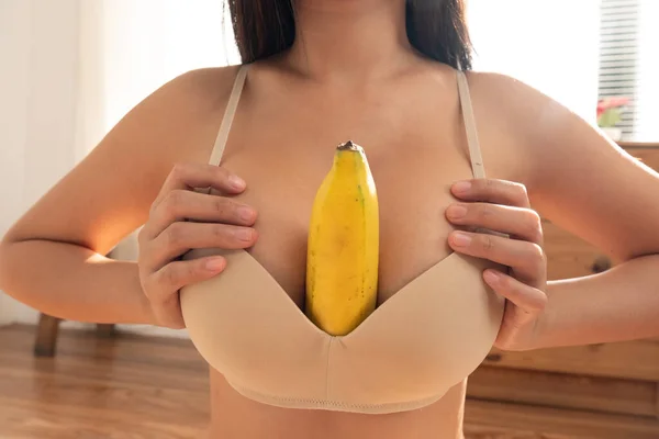 セクシー女性保ちます黄色バナナで彼女の胸 — ストック写真