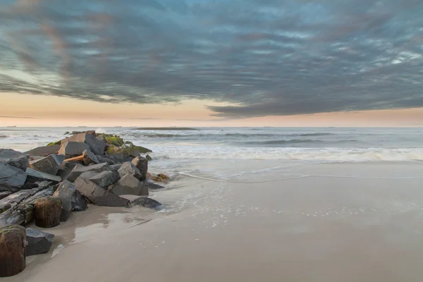 Скалы на песчаном пляже Лицензионные Стоковые Изображения