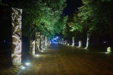 Lutsk (Ukrayna) parkında canavar heykelleriyle dolu bir gece sokağı.).