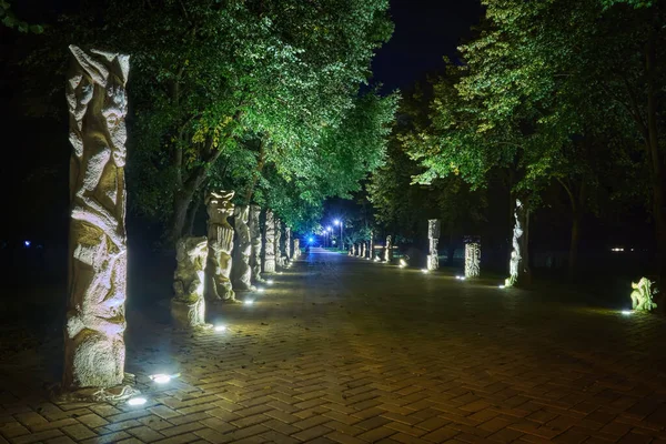Lutsk (Ukrayna) parkında canavar heykelleriyle dolu bir gece sokağı.).