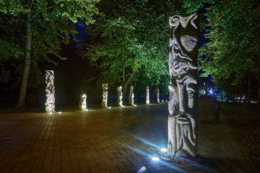 Lutsk (Ukrayna) parkında canavar heykelleriyle dolu bir gece sokağı.).