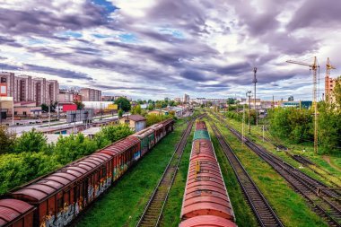Şehir binalarının ortasında şafak vakti kasvetli havada demiryolu kavşağı..