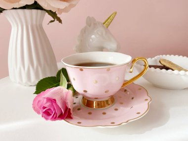 Hafif arka planda gül çiçekli bir fincan çay.