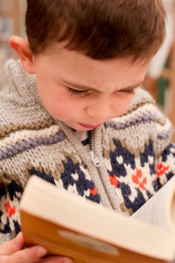 Little boy reading a book clipart