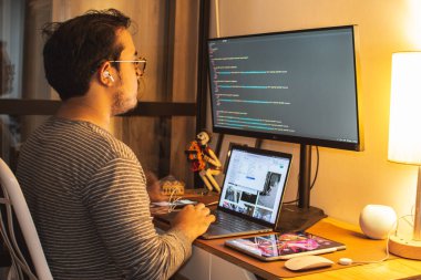 Ofiste çalışan programcı, web geliştirici, tasarımcı mobil ve masaüstü web siteleri sürümlerini karşılaştıran Meksikalı Latince telefon tutan