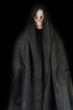 Karanlıktaki siyah başlıklı insan kafatası cadılar bayramı arka planında.