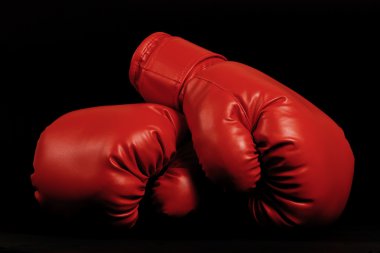 Vintage boxing gloves emerging from black background clipart