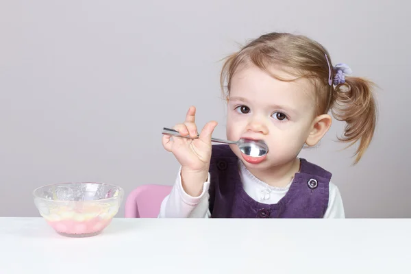 Bebé chica tener divertido mientras comer Imagen De Stock