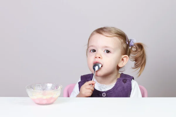 Bebé chica tener divertido mientras comer Fotos De Stock