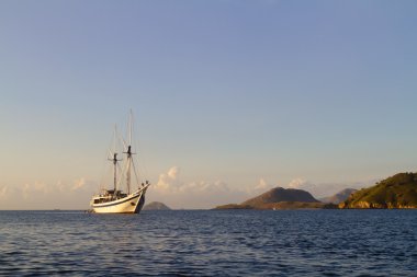Beyaz scooner Bali, Endonezya camsı okyanus yüzeyindeki yelken