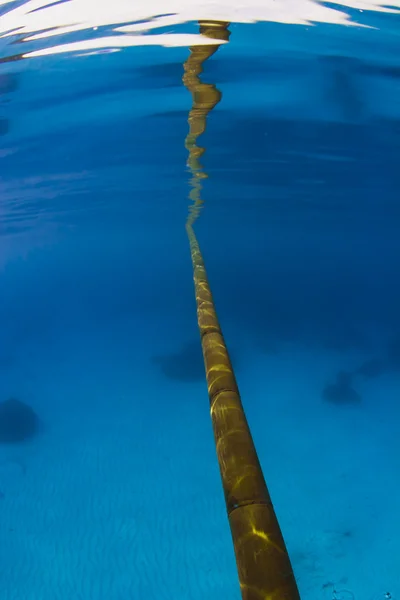 Bambu pole reflektion i havsytan över sandbotten — Stockfoto