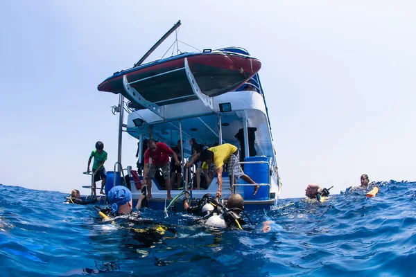 Scuba divers climbing back on dive boat in Similn Islands, Thailand