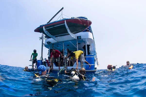 Scuba δύτες αναρρίχηση πίσω σε κατάδυση με σκάφος στα νησιά similn, Ταϊλάνδη Royalty Free Φωτογραφίες Αρχείου